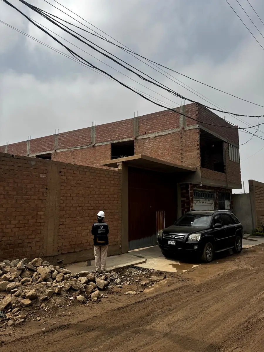 Supervisor frente a una vivienda de ladrillo en obra