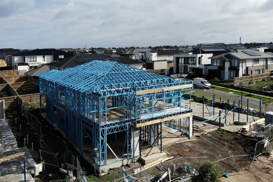 Vista aérea de una vivienda en construcción con estructura azul